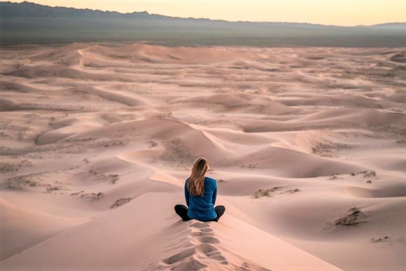 Femme assise dans le désert de Gobi observant les dunes - Mongolie | Au Tigre Vanillé