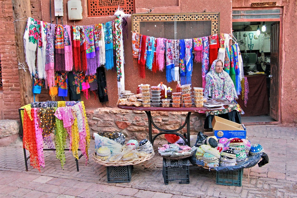 abyaneh-ocre-tissus-marche-iran Marchande dans la rue à Abanyeh - Iran | Au Tigre Vanillé