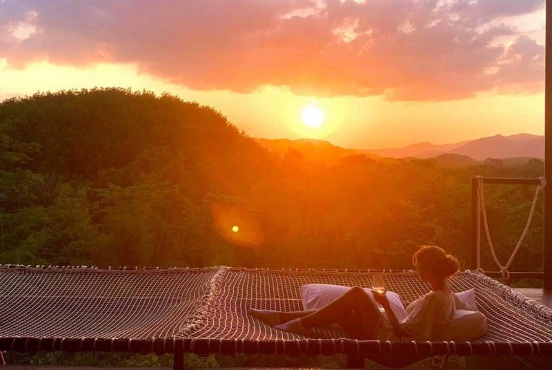 Apéro sur des filets suspendus avec vue sur la jungle au coucher du soleil à l'hotel glamping Tanoshi à Khao Sok - Thaïlande | Au Tigre Vanillé