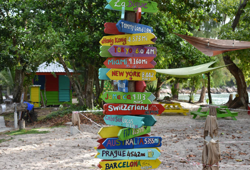 Seychelles, La Digue, panneaux indiquant les villes du monde et leur distance